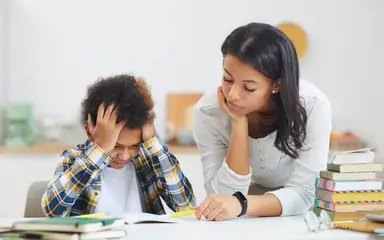 Mother helping child with schoolwork.